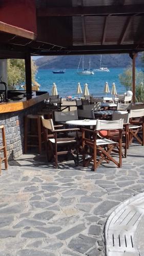 a group of tables and chairs in front of the ocean at Lena Apartments in Elounda