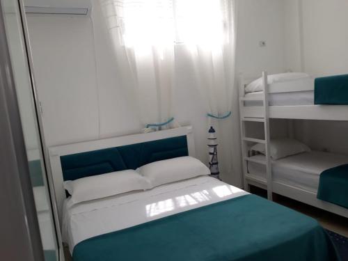 ein kleines Schlafzimmer mit einem Bett und Etagenbetten in der Unterkunft Blue Coral apartament in Velipojë