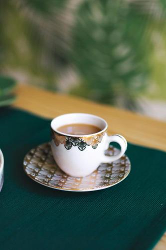 a cup of tea sitting on a plate on a table at Apartamenty Willove Wzgórze in Duszniki Zdrój