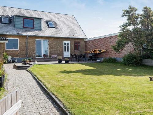 a brick house with a lawn in front of it at 4 person holiday home in Esbjerg V in Esbjerg