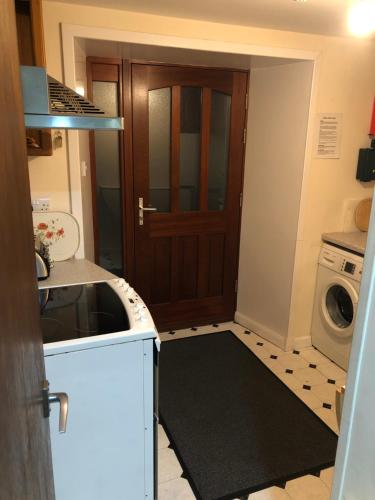 a kitchen with a washer and dryer next to a door at Cosy holiday home, Scalloway, Shetland. in Scalloway