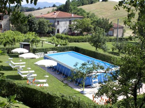 an outdoor swimming pool with chairs and umbrellas at Belvilla by OYO Gesso Piccolo in Sassoleone