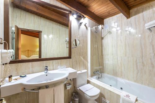 a bathroom with a sink and a toilet and a tub at Hotel Sao Joao De Deus by RIDAN Hotels in Elvas