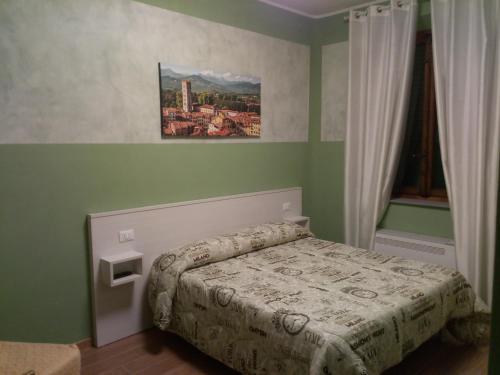 1 dormitorio con 1 cama y una pintura en la pared en Affittacamere Rossi, en Lucca
