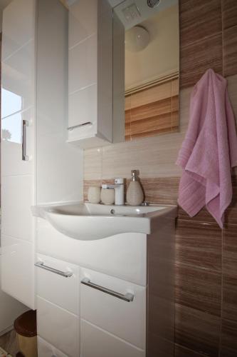 a bathroom with a sink and a pink towel at Apartman Lucija & Luka in Otočac