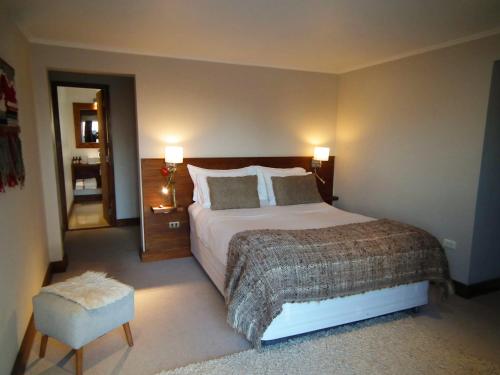 a bedroom with a large bed and a chair at Hotel K in Bahia Inglesa