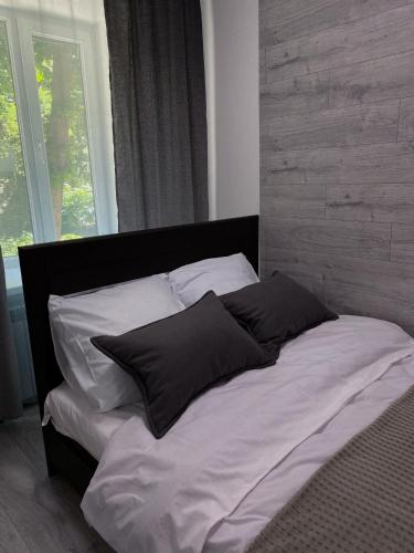 a bed with two pillows on it in a bedroom at Затишні апартаменти подобово,центр in Ternopilʼ