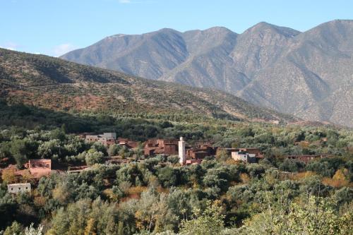 a village on a hill with mountains in the background at Kasbah Africa - High Atlas Dark Sky & Nature Lodge in Ouirgane