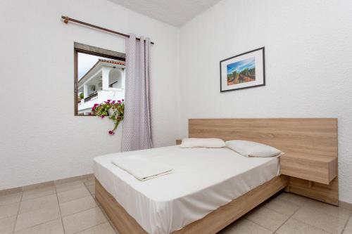 a bedroom with a bed and a window at George's Apartments in Skala Fourkas