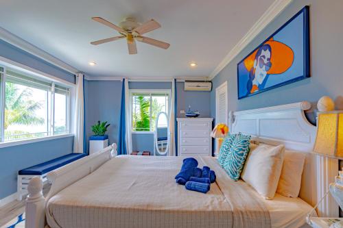a bedroom with a large bed with a ceiling fan at Villa Northwinds - At Orange Hill - Private Pool in Nassau