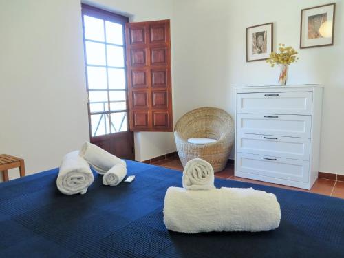 um quarto com toalhas numa cama com uma cómoda em CAIS APARTMENT by Stay in Alentejo em Vila Nova de Milfontes