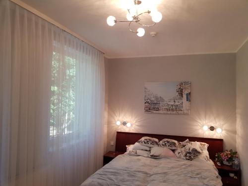 a bedroom with a bed with a woman on it at Apartament Polonia in Kołobrzeg