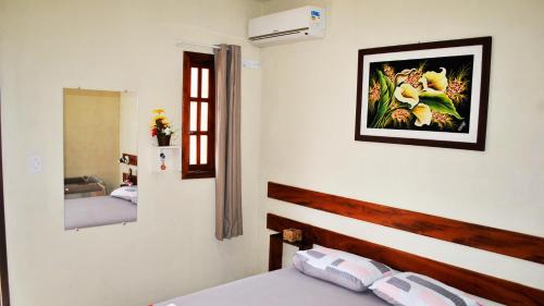 a bedroom with a bed and a picture on the wall at Residencial Atlântico Sul in Paraty
