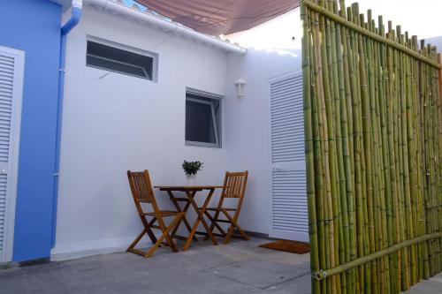 a patio with a table and chairs and a fence at Estúdio Azul in Ponta Delgada