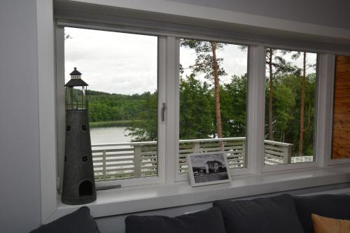 a window in a living room with a view of a lighthouse at Przystań na Zagórzu - Apartamenty nad jeziorem in Drezdenko