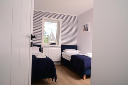 a small room with two beds and a window at Przystań na Zagórzu - Apartamenty nad jeziorem in Drezdenko