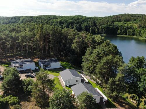 een luchtzicht op een huis en een meer bij Przystań na Zagórzu - Apartamenty nad jeziorem in Drezdenko