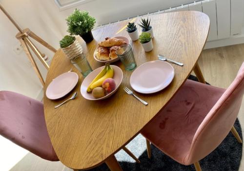 a wooden table with plates of food on it at Bons Baisers du Touquet - Le Parc in Cucq