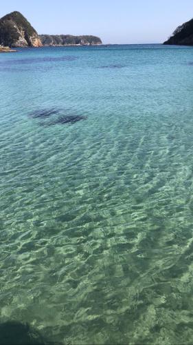 a large body of water with rocks in the background at Guesthouse All you need - All rooms have an ocean view! in Shimoda