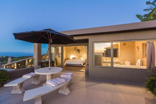 a bedroom with a bed and an umbrella on a balcony at Delamore Lodge in Oneroa