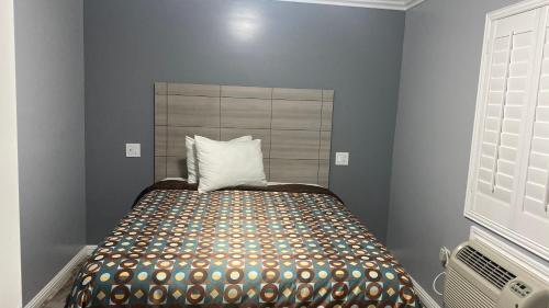 a bedroom with a bed with a pillow on it at La Perla motel in South Gate
