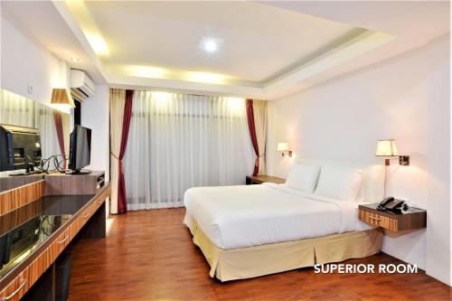 a hotel room with a bed and a television at Kasira Residence in Jakarta