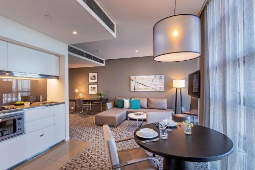 a kitchen and living room with a table and a couch at Fraser Suites Sydney in Sydney