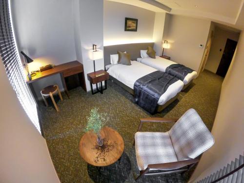 Cette chambre comprend un lit, un bureau et une chaise. dans l'établissement Hotel S-Presso South, à Osaka
