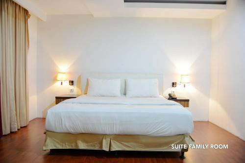a bedroom with a large bed with white sheets and pillows at Kasira Residence in Jakarta