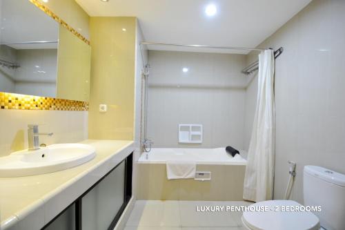 y baño con lavabo, aseo y ducha. en Kasira Residence, en Yakarta