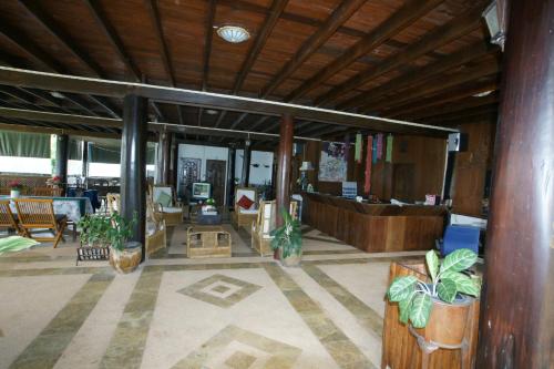 a living room with a lobby with potted plants at Ruen Thai Rim Haad in Klaeng