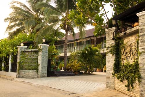 an entrance to a building with palm trees at บ้านชมเขา - Baan Chom Khao in Pak Chong