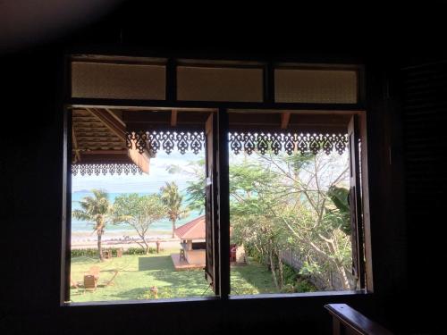 a window in a room with a view of the beach at Ruen Thai Rim Haad in Klaeng