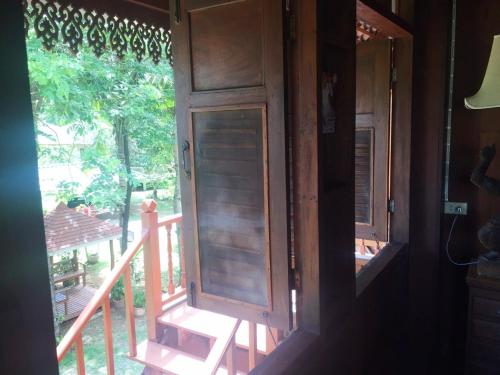 an open door of a house with a porch at Ruen Thai Rim Haad in Klaeng