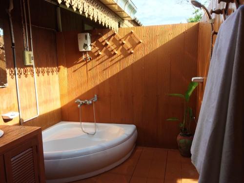 a bathroom with a bath tub and a sink at Ruen Thai Rim Haad in Klaeng