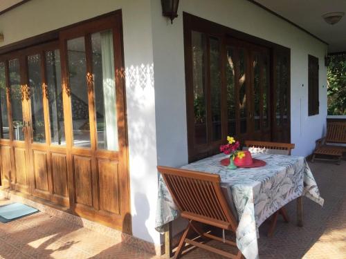 a table with a bowl of fruit sitting on a porch at Ruen Thai Rim Haad in Klaeng