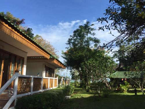 a house with a fence and trees in the yard at Ruen Thai Rim Haad in Klaeng