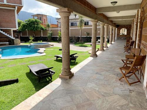 an outdoor patio with a swimming pool and columns at La Buena Suerte in Tepoztlán