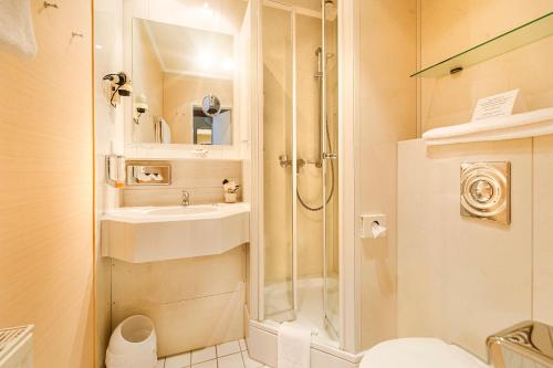 y baño con ducha y lavamanos. en Akzent Hotel Berlin, en Bad Bevensen