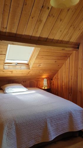 ein Schlafzimmer mit einem Bett in einem Holzzimmer in der Unterkunft Domaine de la Queyrie in Sarlat-la-Canéda
