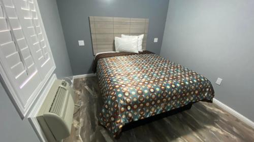 a small bedroom with a bed in a room at La Perla motel in South Gate