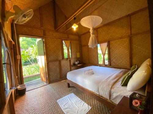 ein Schlafzimmer mit einem Bett in einem Zimmer mit einem Fenster in der Unterkunft Farmstay at Pai in Pai