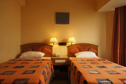 a hotel room with two beds in a room at Bangkok City Inn in Bangkok