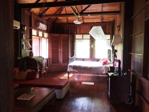 a bedroom with a bed and a couch in a room at Ruen Thai Rim Haad in Klaeng