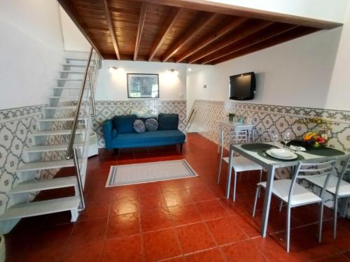 a living room with a blue couch and a table at Casa Pacheco in Furnas