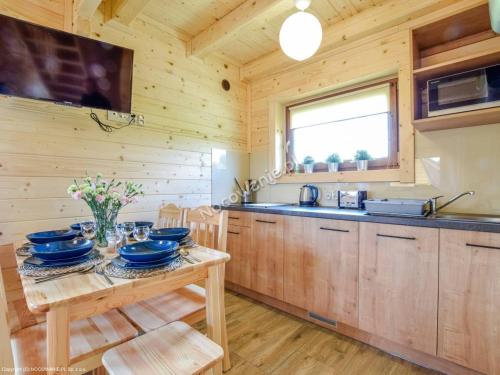 una cocina de madera con una mesa con platos. en Całoroczne Domki Zaciszna Polana, en Polanica-Zdrój