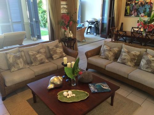 a living room with a couch and a table at Eden Island Luxury Accommodation in Eden Island