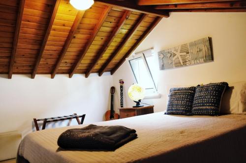 a bedroom with a large bed with wooden ceilings at Casa Pacheco in Furnas