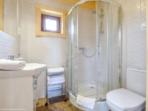 een badkamer met een douche, een toilet en een wastafel bij Całoroczne Domki Zaciszna Polana in Polanica-Zdrój