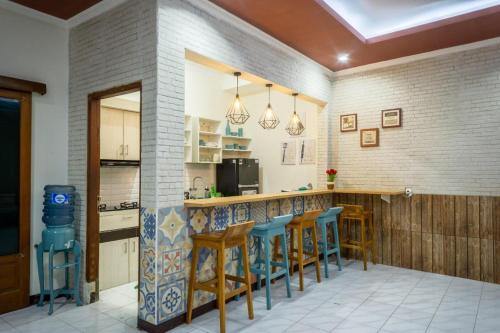 a kitchen with a bar with blue stools at Zenrra House in Bandung